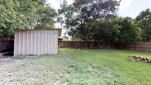 a view of a house with a yard and large tree