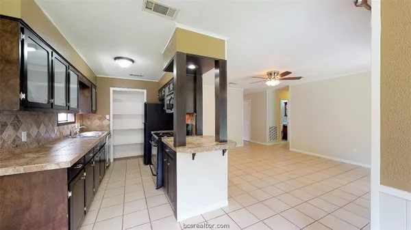 a kitchen with refrigerator and cabinets