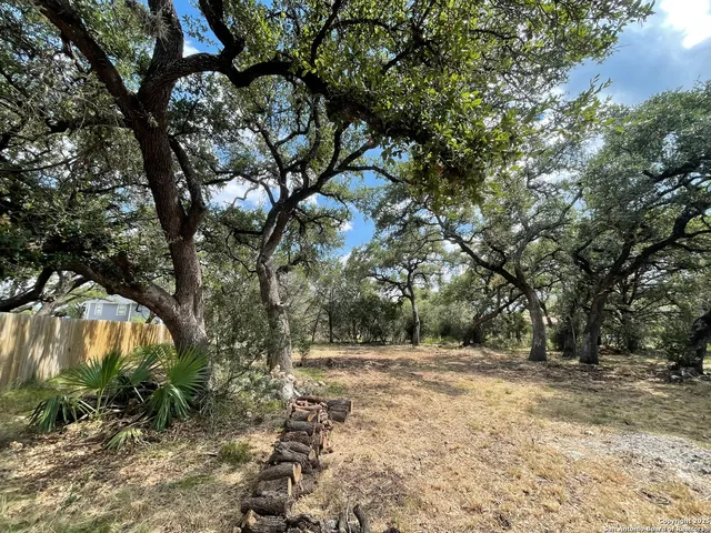 an aerial view of a wooden table and chairs