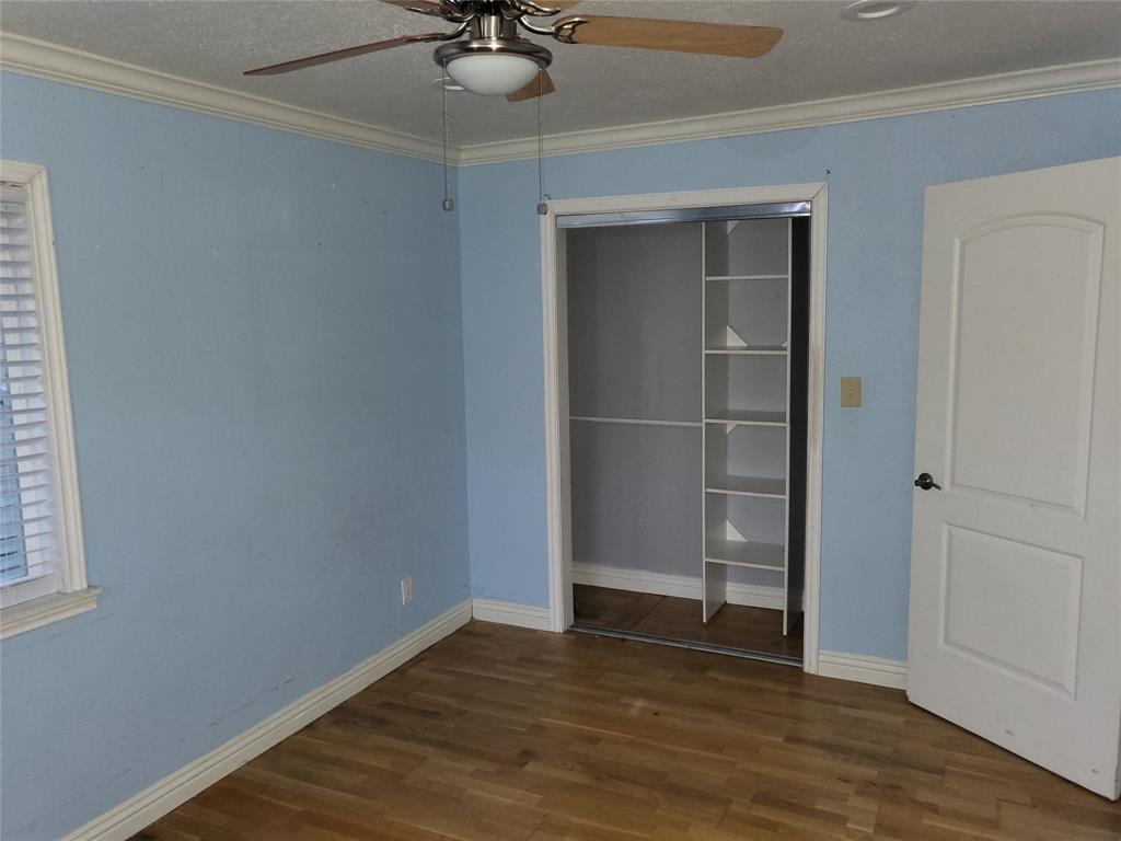 623 West Mesquite Street Jacksboro, TX 76458 - Photo 12 of 25 a view of an empty room with a window and wooden floor