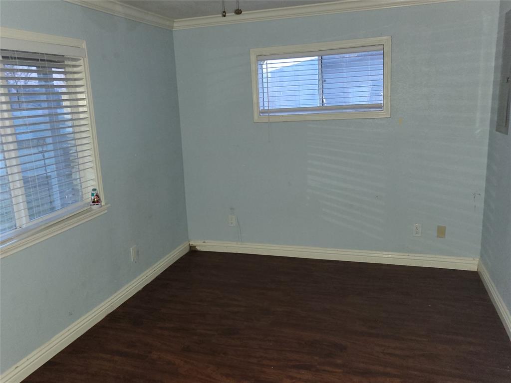 623 West Mesquite Street Jacksboro, TX 76458 - Photo 14 of 25 a view of an empty room with wooden floor and a window