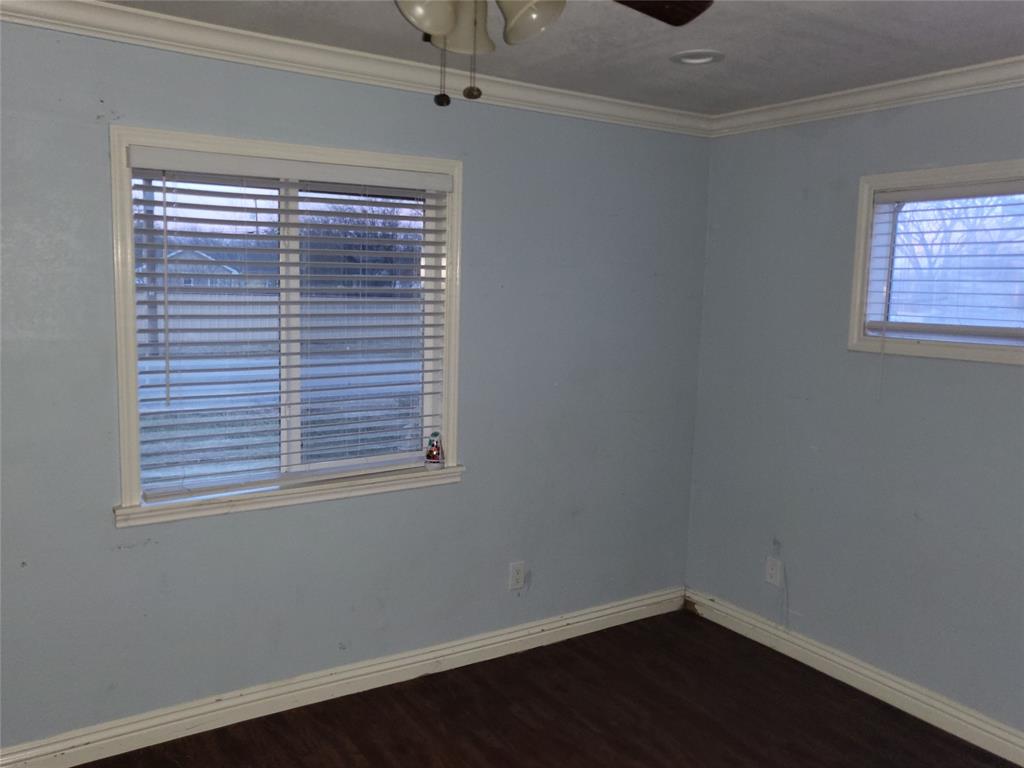 623 West Mesquite Street Jacksboro, TX 76458 - Photo 15 of 25 a view of an empty room with wooden floor and a window