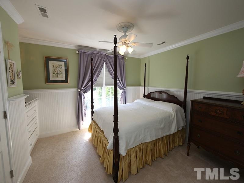 204 Okamato Street Raleigh, NC 27603 - Photo 13 of 25 a bedroom with a bed and a chandelier