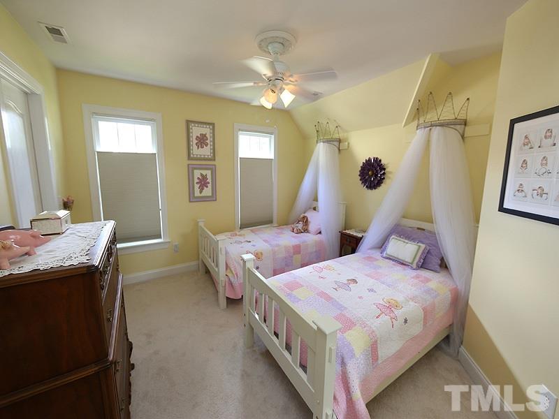 204 Okamato Street Raleigh, NC 27603 - Photo 16 of 25 a bedroom with two beds and a chandelier
