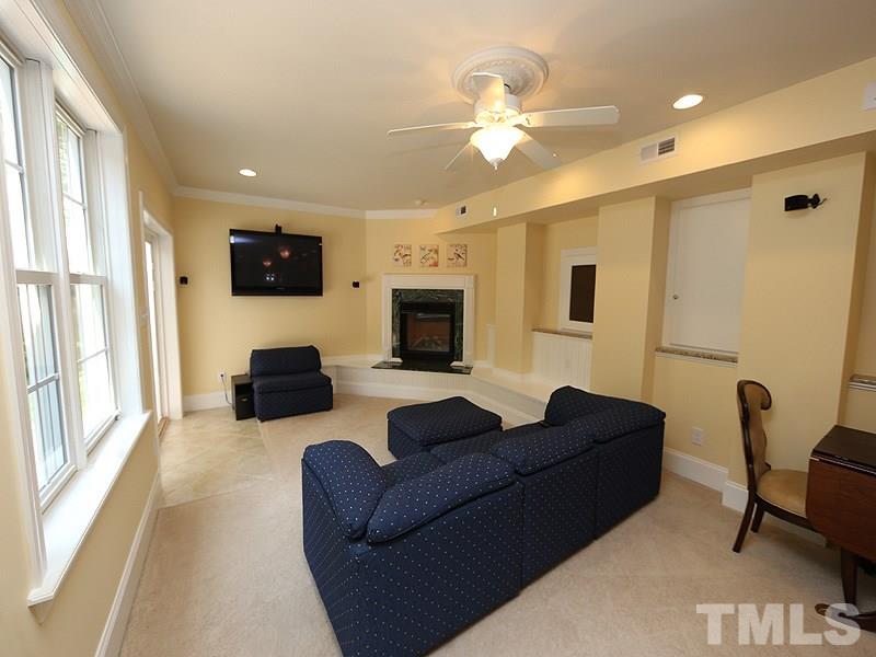 204 Okamato Street Raleigh, NC 27603 - Photo 17 of 25 a living room with furniture a fireplace and a flat screen tv