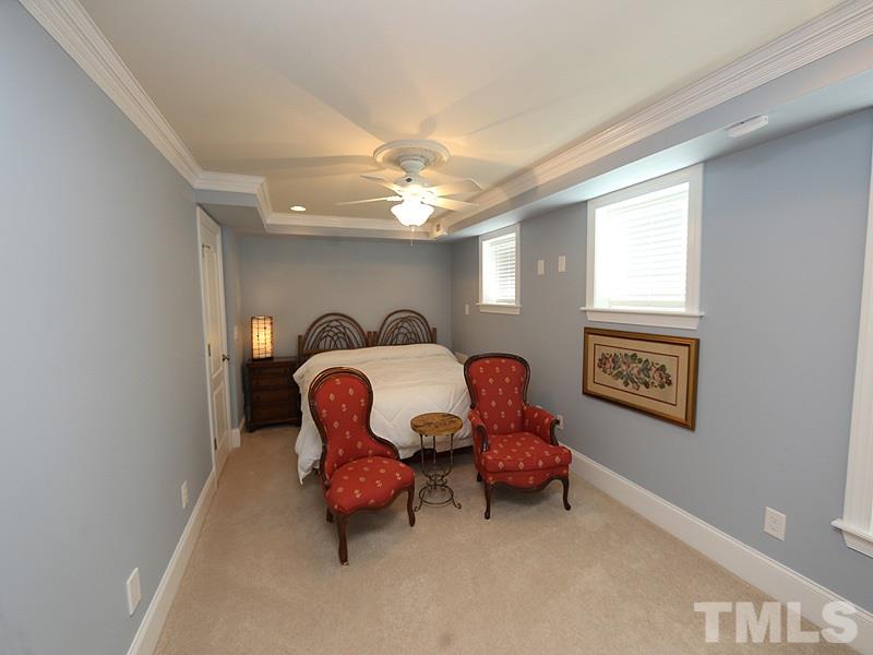 204 Okamato Street Raleigh, NC 27603 - Photo 19 of 25 a bedroom with furniture and a chandelier