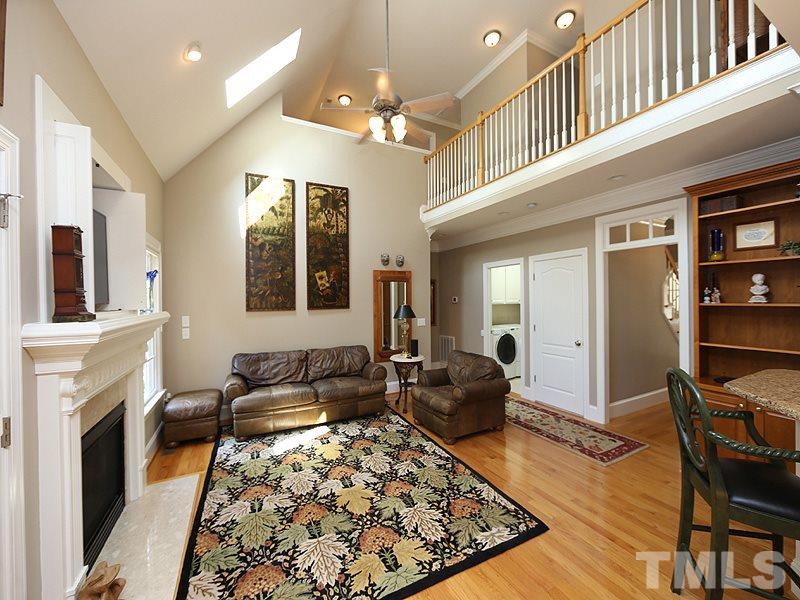 204 Okamato Street Raleigh, NC 27603 - Photo 7 of 25 a living room with furniture a fireplace and a chandelier