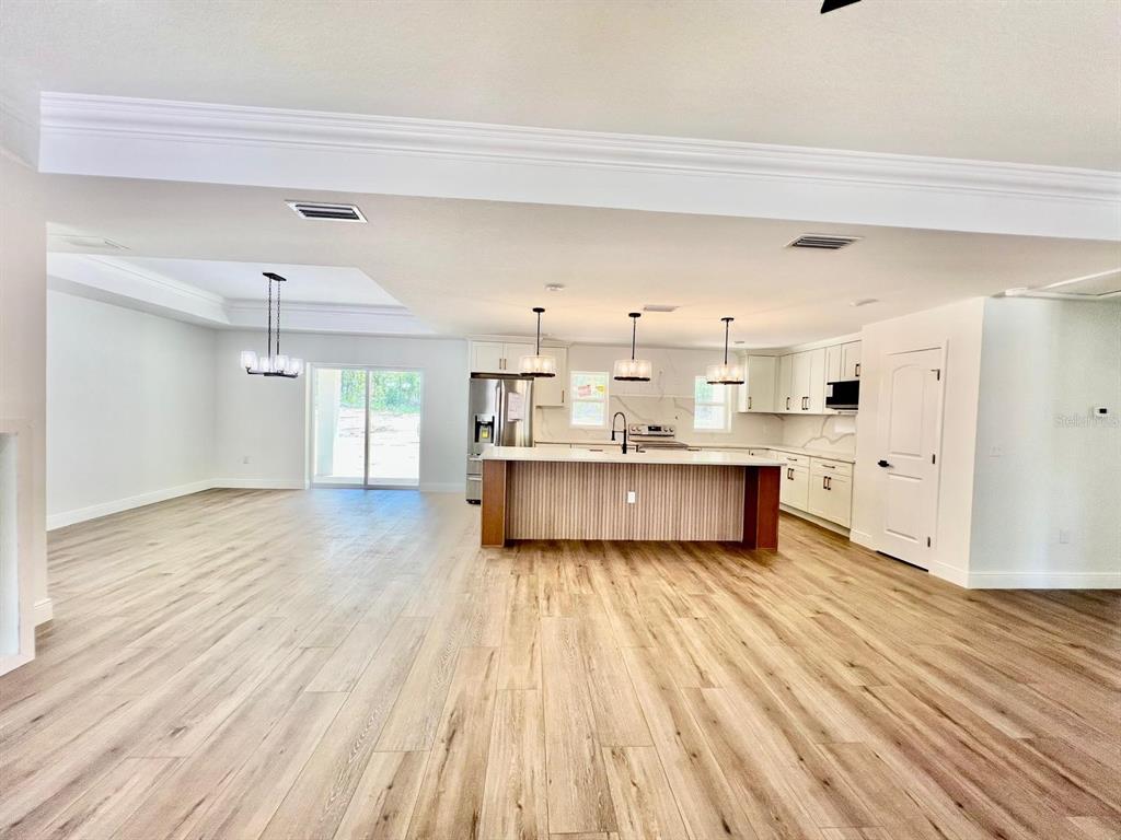 13322 Southwest 66th Street Ocala, FL 34481 - Photo 3 of 15 a living room with kitchen and wooden floors