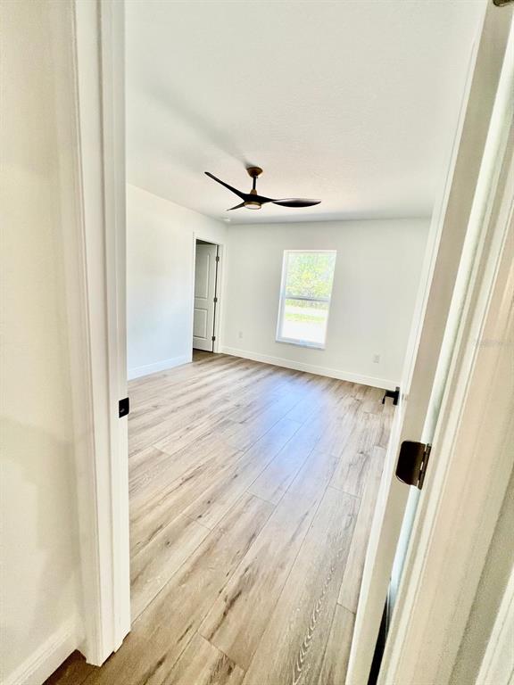 13322 Southwest 66th Street Ocala, FL 34481 - Photo 7 of 15 a view of a livingroom with wooden floor and a ceiling fan