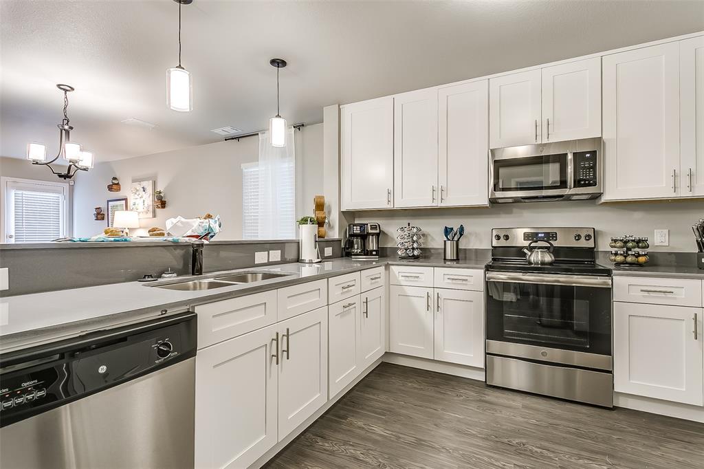 3816 Sheraton Road Denton, TX 76209 - Photo 10 of 40 a kitchen with stainless steel appliances granite countertop a sink a stove a microwave and cabinets