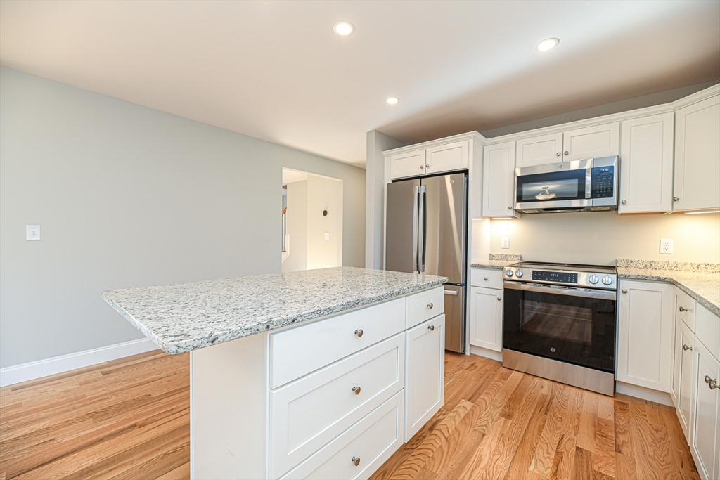 3 Delphi Way Londonderry, NH 03053 - Photo 12 of 20 a kitchen with stainless steel appliances granite countertop a stove a sink and a refrigerator