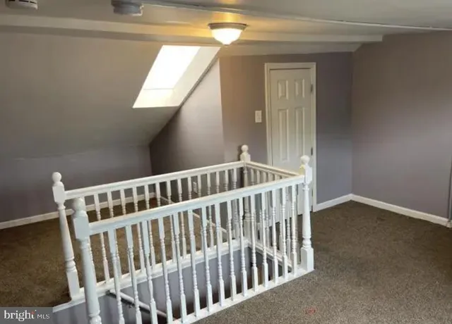 a view of staircase with railing and a rug