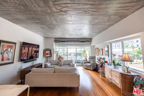 a living room with furniture a flat screen tv and a large window