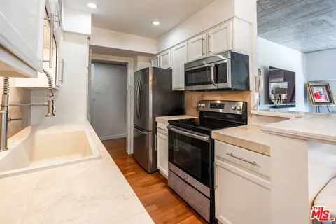 a kitchen with stainless steel appliances a stove a microwave and a refrigerator