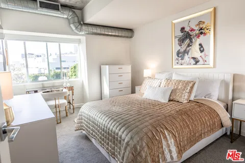 a bedroom with a bed and a large window