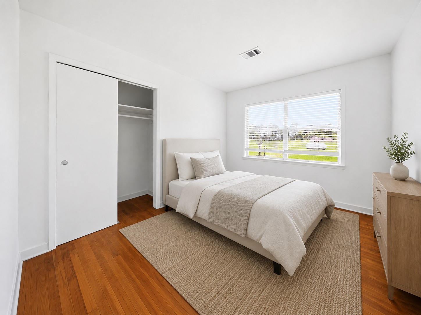 5443 Randon School Road Rosenberg, TX 77471 - Photo 14 of 20 Secondary bedroom with warm wood flooring, bright white walls, large window with blinds, and closet storage.