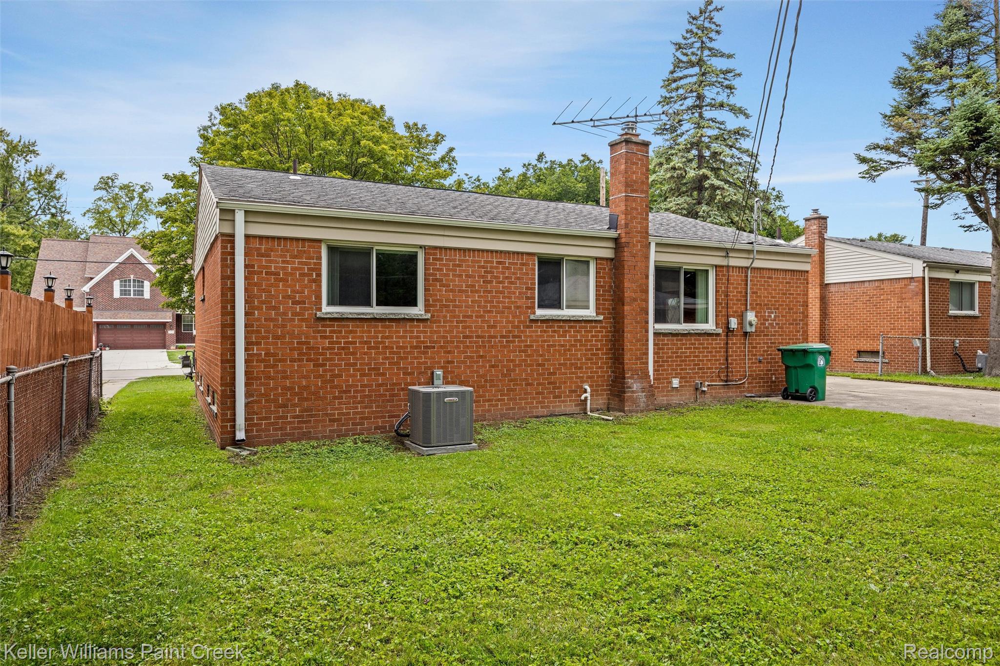 1766 Henry Ruff Road Garden City, MI 48135 - Photo 27 of 36 Brick exterior with a prominent chimney, equipped with an exterior HVAC unit, and a chain-link fence bordering the property