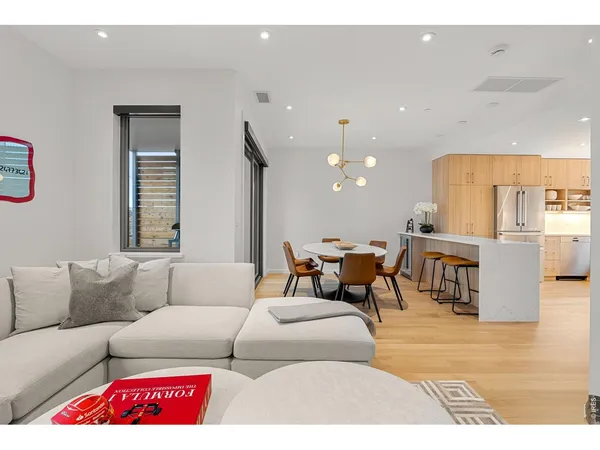 a living room with furniture and a dining table with kitchen view