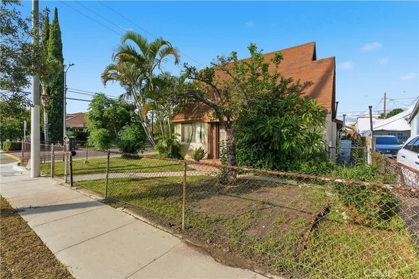 a view of a house with backyard and a tree