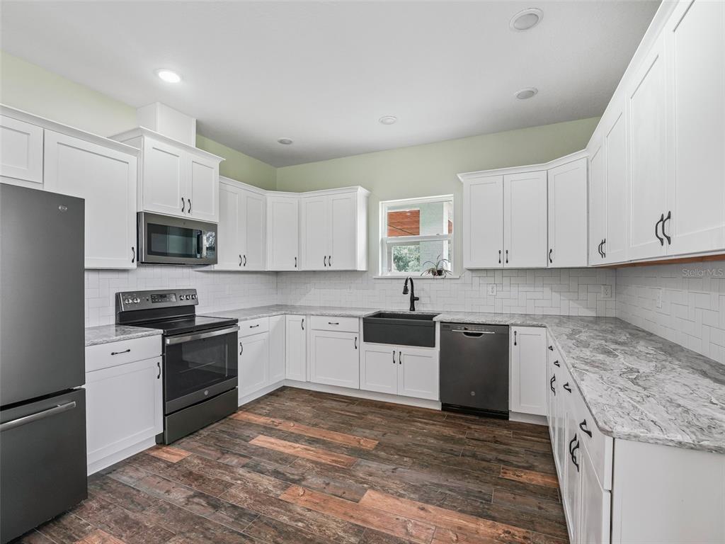 8567 Cr 635 Bushnell Bushnell, FL 33513 - Photo 13 of 46 a kitchen with granite countertop white cabinets and stainless steel appliances