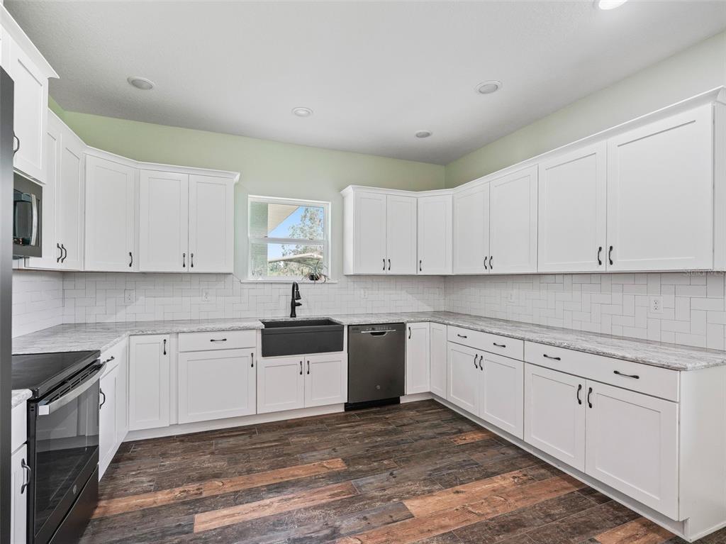 8567 Cr 635 Bushnell Bushnell, FL 33513 - Photo 14 of 46 a kitchen with granite countertop white cabinets and white appliances