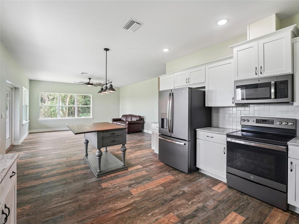 8567 Cr 635 Bushnell Bushnell, FL 33513 - Photo 15 of 46 a kitchen with stainless steel appliances a stove a refrigerator and a microwave