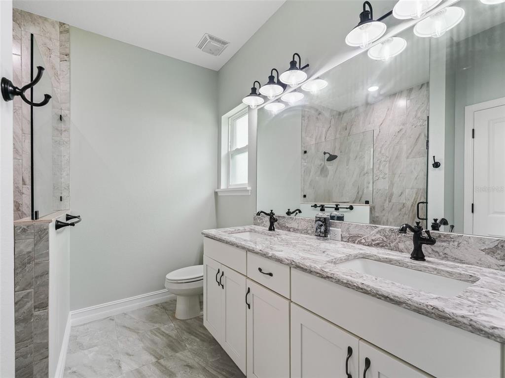 8567 Cr 635 Bushnell Bushnell, FL 33513 - Photo 23 of 46 a bathroom with a granite countertop sink a toilet and a mirror