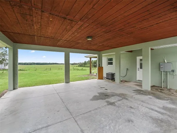a view of an empty room with a floor to ceiling window and yard