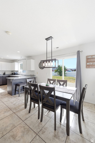 5485 Heather Way Tooele, UT 84074 - Photo 18 of 41 Dining area featuring tile flooring, a linear chandelier, and a sliding glass door