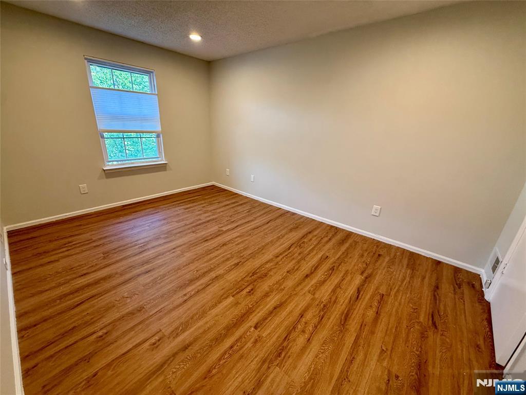 197 Larch Lane Mahwah, NJ 07430 - Photo 8 of 11 an empty room with wooden floor and windows