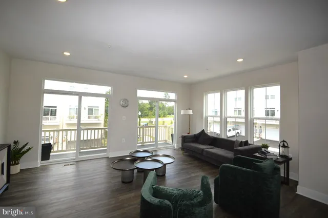 a living room with furniture and floor to ceiling windows