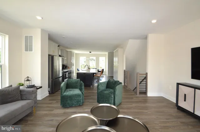 a living room with furniture kitchen view and a window