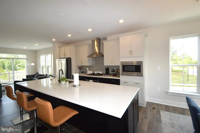 a kitchen with stainless steel appliances a table chairs and a refrigerator