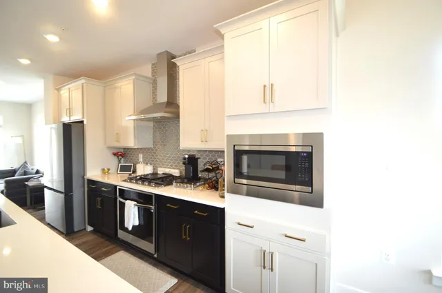 a kitchen with stainless steel appliances a stove a sink and a refrigerator