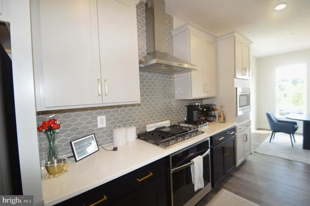 a kitchen with stainless steel appliances granite countertop a sink stove and cabinets