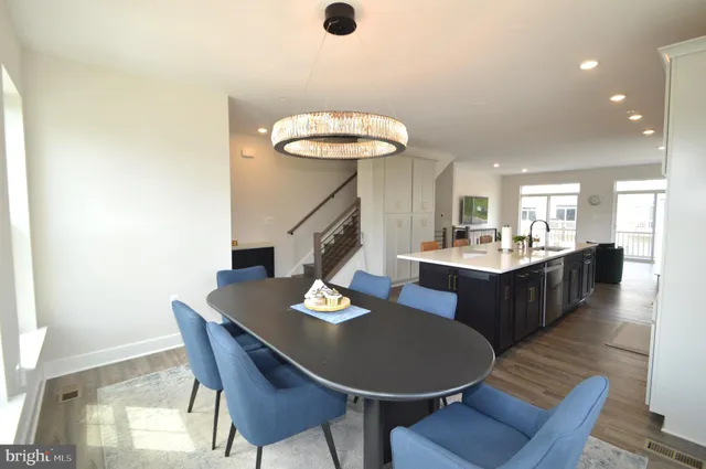 a dining room with a table chairs and a kitchen view