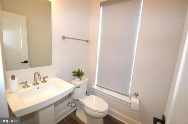 a bathroom with a sink toilet and a mirror