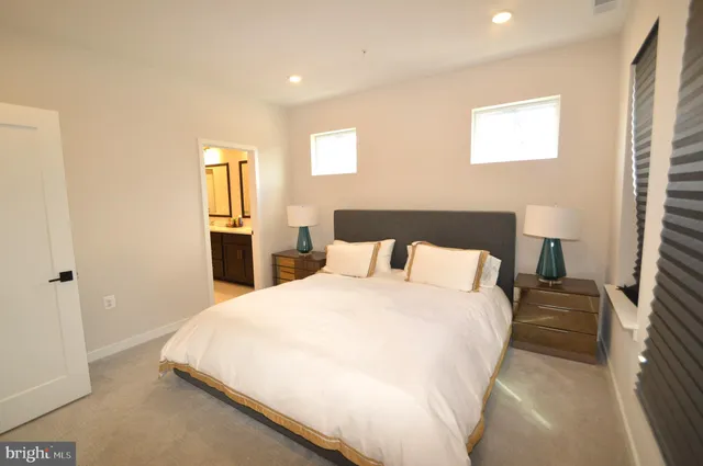 a large bed in a bedroom next to a window