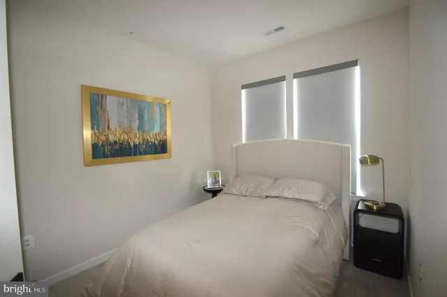 a bedroom with a bed and a painting on the wall