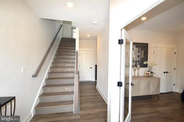 a view of a hallway with wooden floor and staircase