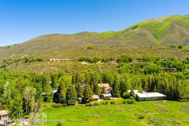 an aerial view of residential house with swimming pool and trees