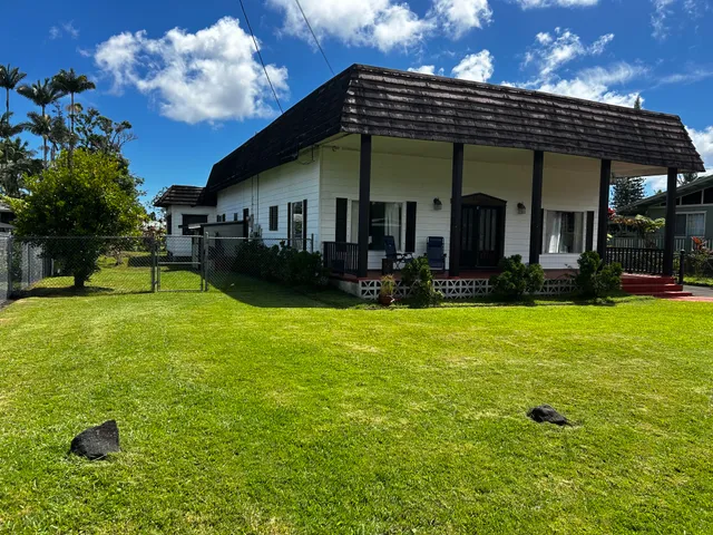 a view of a house with a yard balcony and sitting area