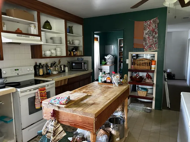 a kitchen with a stove a refrigerator and a dining table