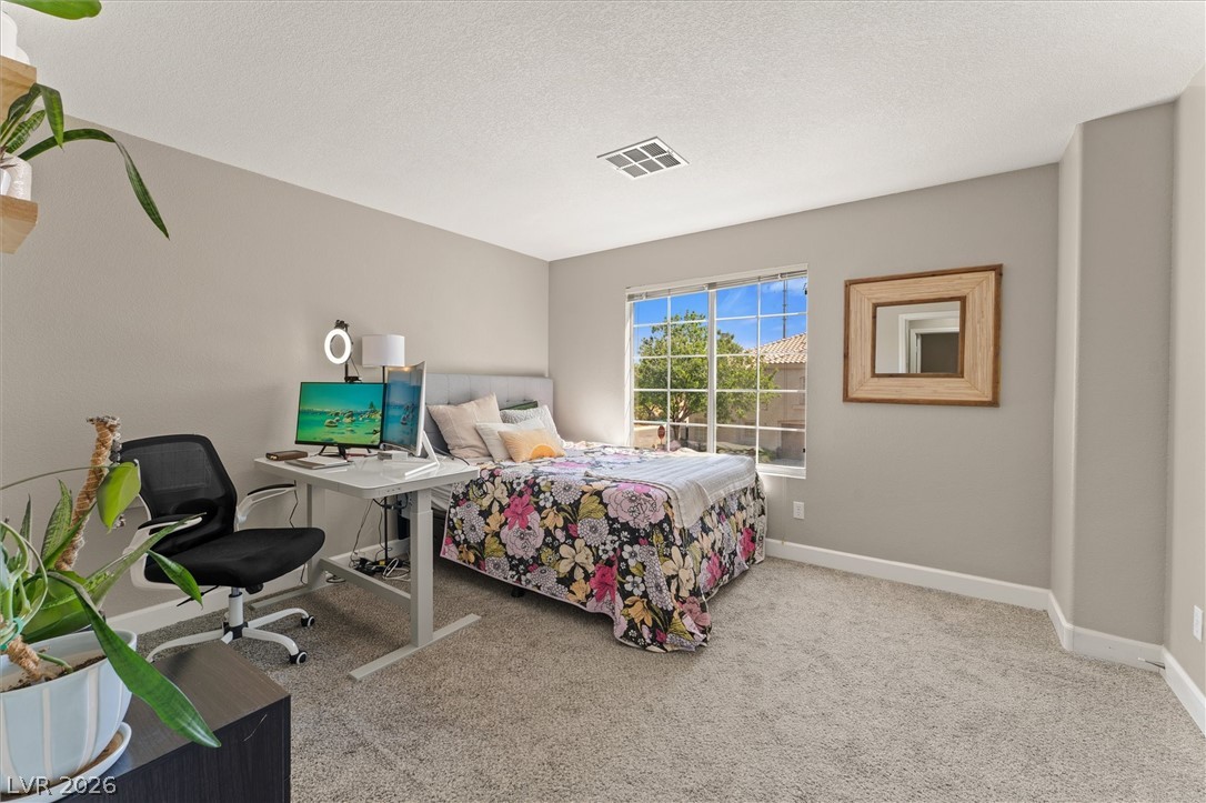 503 Rafkin Place Henderson, NV 89052 - Photo 12 of 18 A restful bedroom offers a large window and cozy carpeting, perfect for quiet retreats or productive work from home.