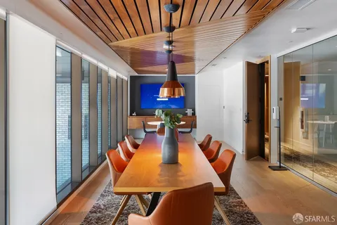 a view of a dining room with furniture wooden floor and a potted plant