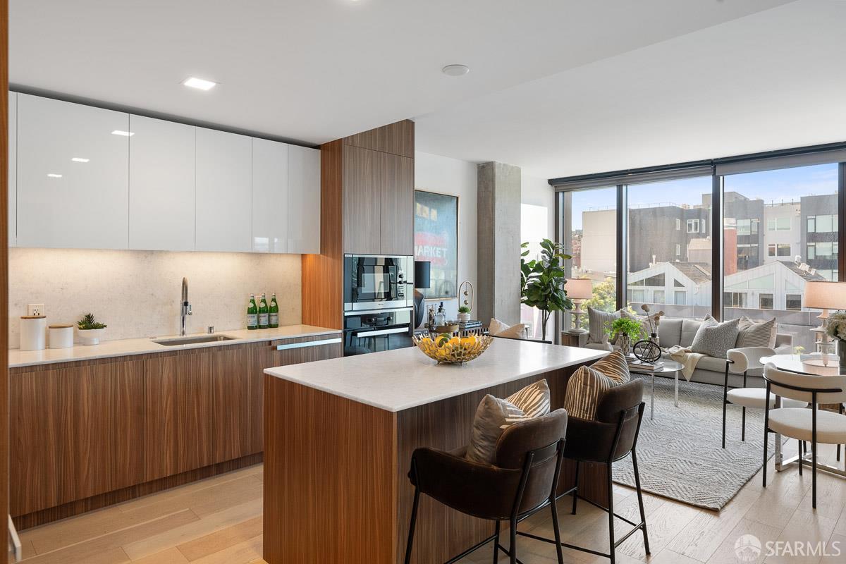 2177 3rd Street, Unit 609 San Francisco, CA 94107 - Photo 8 of 32 a kitchen with a dining table chairs and white appliances