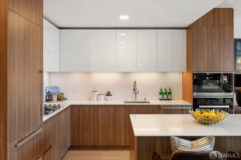 a kitchen with a sink a stove and wooden cabinets