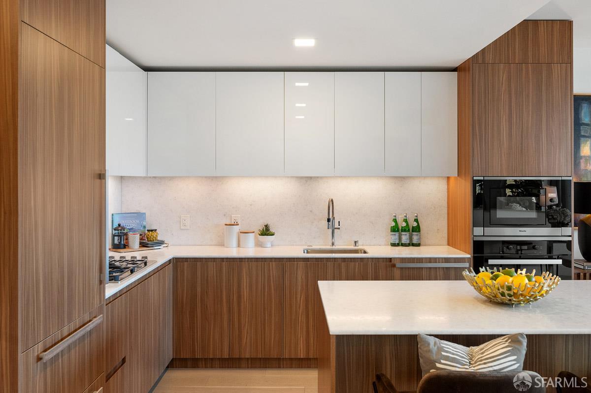 2177 3rd Street, Unit 609 San Francisco, CA 94107 - Photo 10 of 32 a kitchen with a sink a stove and wooden cabinets