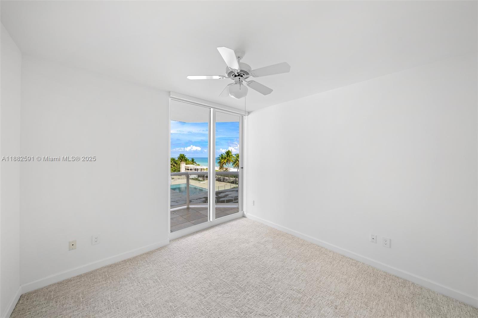 4779 Collins Avenue, Unit 501 Miami Beach, FL 33140 - Photo 16 of 45 an empty room with windows and fan