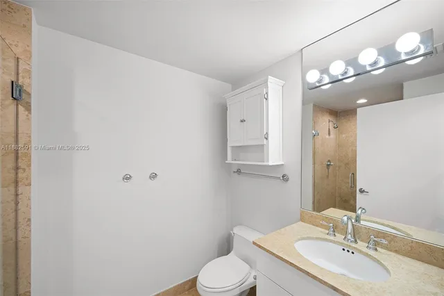 a bathroom with a sink vanity mirror and toilet